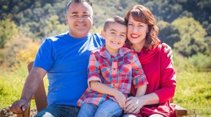 Hispanic family sitting on bench sunny