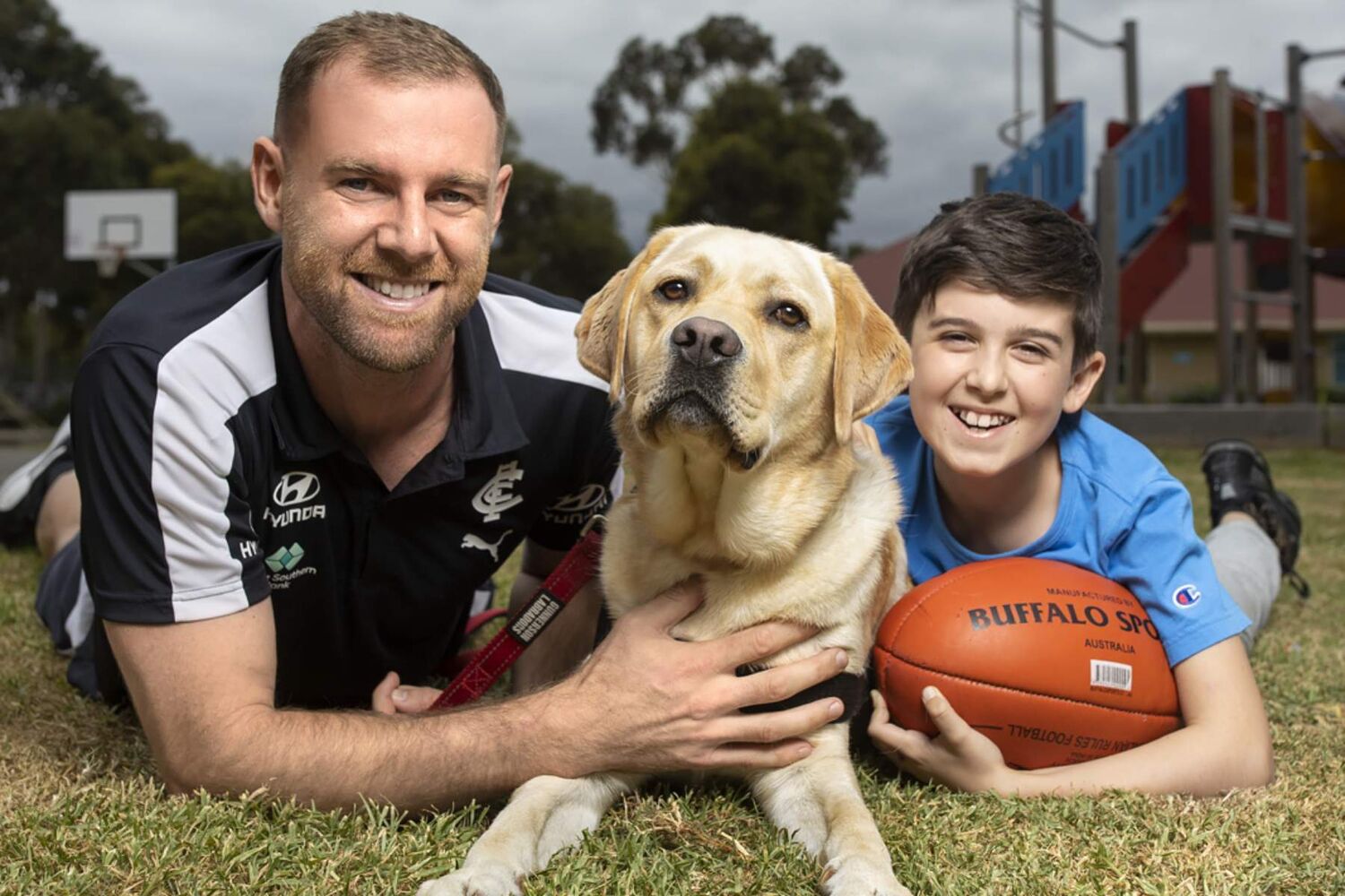 Sam docherty dog and young person holding footy